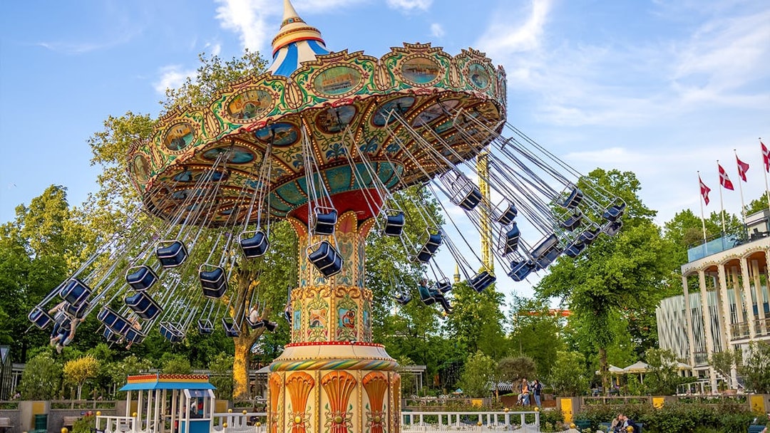 Swing ride at Tivoli Gardens, Copenhagen, with colorful seats and ornate design.