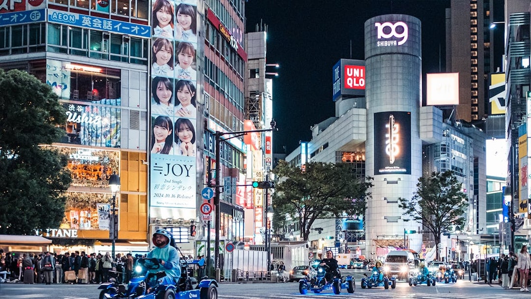 People driving go-karts through Shibuya at night during Shinjuku tour.