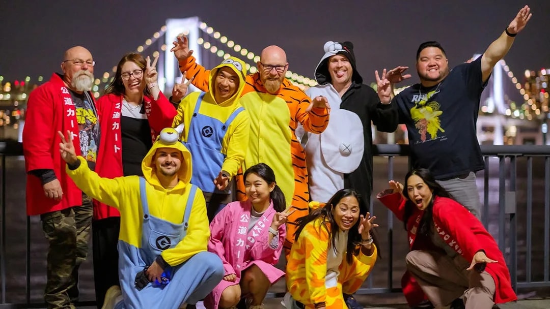 Group in costumes enjoying Asakusa Tour with Rainbow Bridge in background.