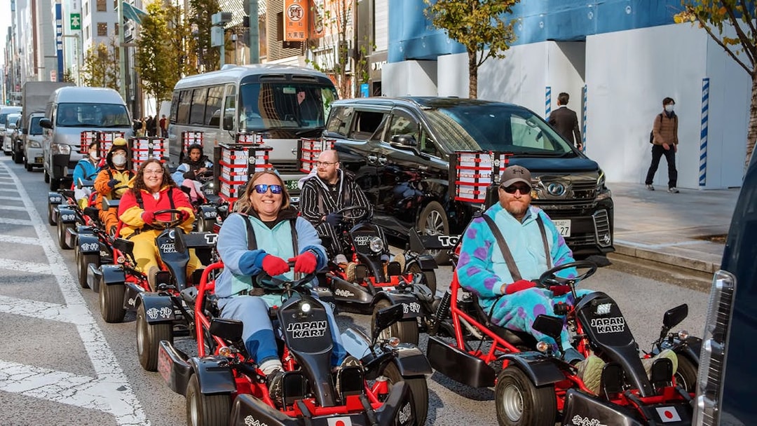 People driving go-karts on Asakusa streets during a 60-minute tour.