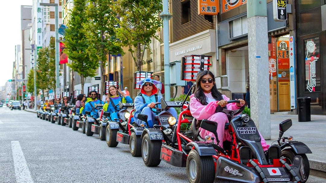 People driving go-karts in costumes on Asakusa streets during a 60-minute tour.