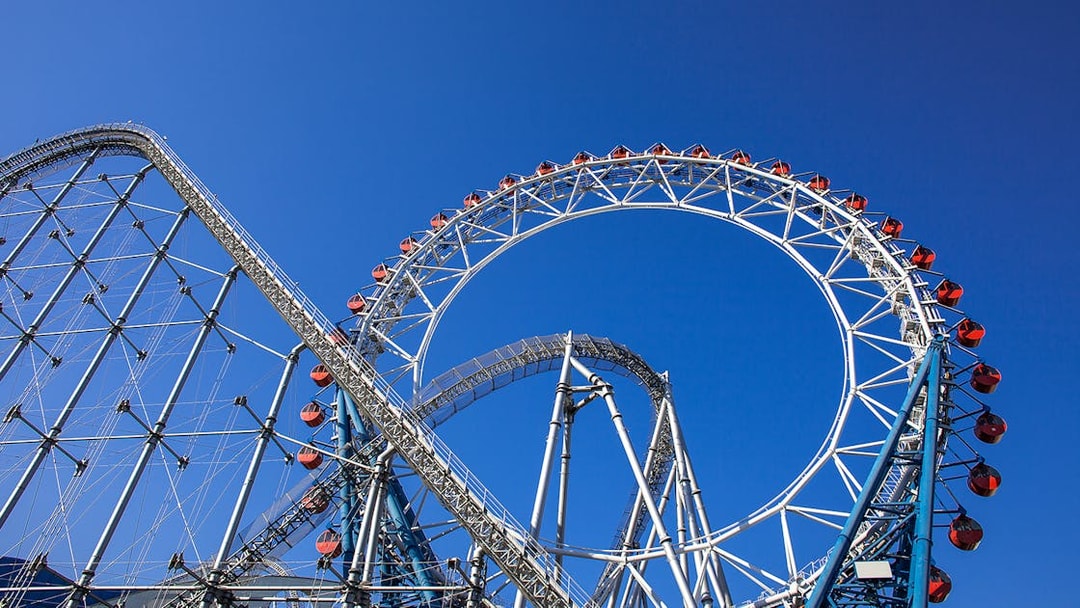 Roller coaster at Tokyo Dome City Attractions against blue sky.