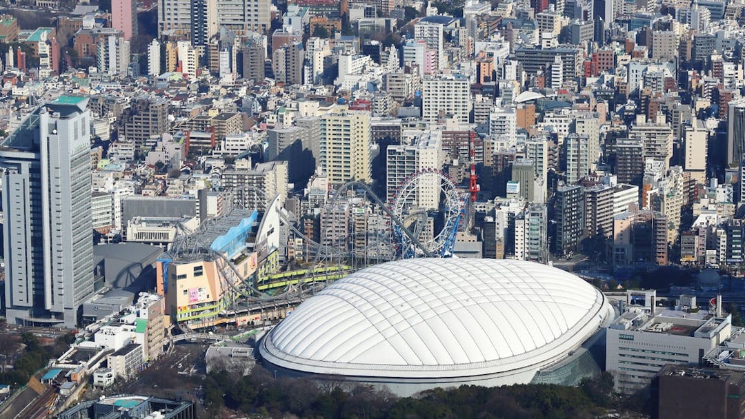 Tokyo Dome City with amusement park rides and surrounding cityscape.