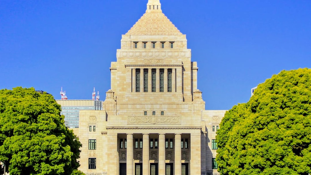 National Diet Building in Tokyo, Japan, with its iconic pyramid roof and surrounding trees.