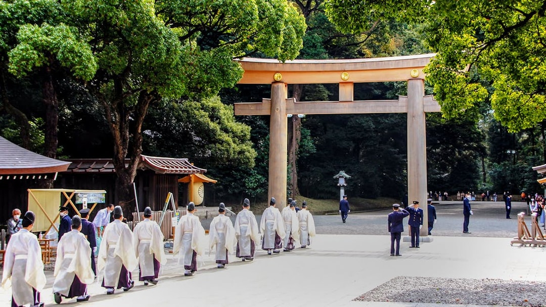 Priests walking under a torii gate at Meiji Jingu Shrine, Tokyo.