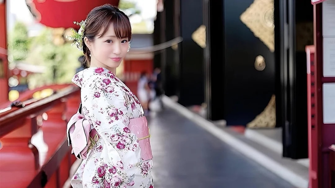 Person in floral kimono at Asakusa, Tokyo, with traditional architecture in the background.