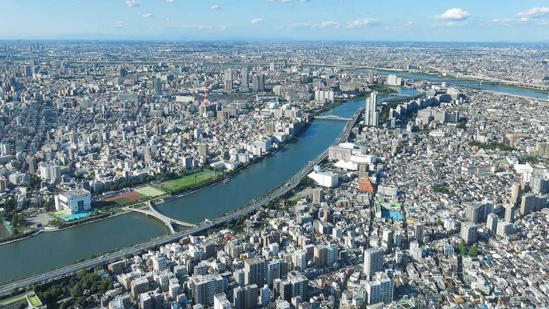 Aerial view of Tokyo cityscape from Tembo Deck and Tembo Galleria, showcasing river and urban landscape.