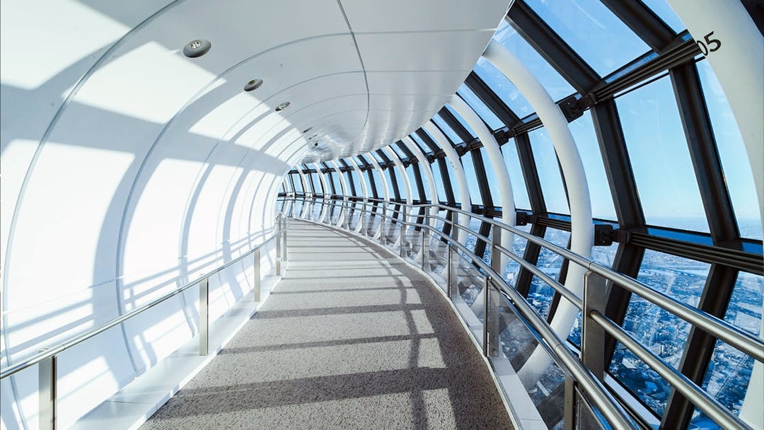 Curved glass corridor inside Tokyo Skytree with city view.