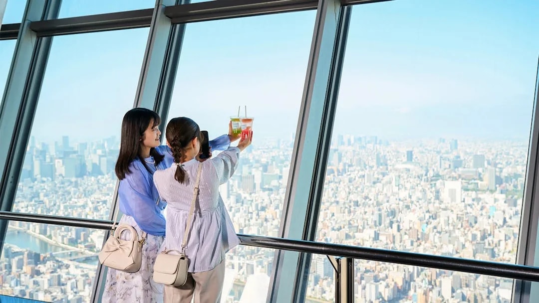 Tourists on Tembo Deck enjoying city view with soft drinks.