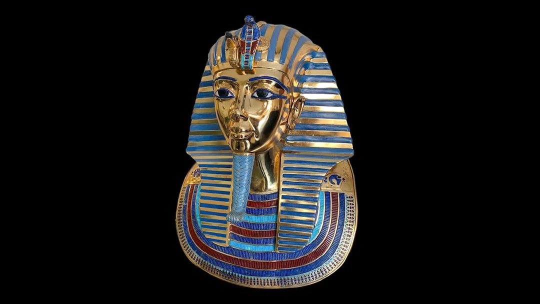 Golden mask of an Egyptian pharaoh with blue stripes, related to Tomb of the Pharaohs.