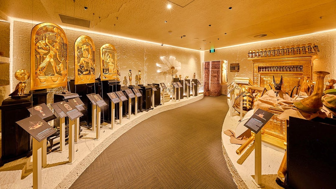 Golden Egyptian artifacts displayed in the Tomb of the Pharaoh exhibit room, Cairns.