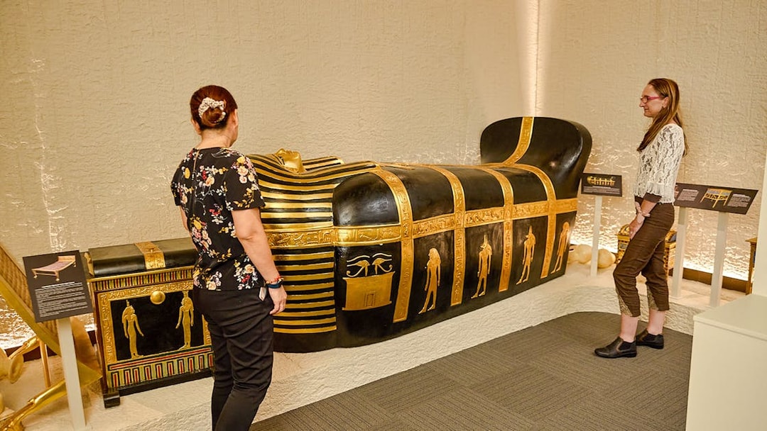Visitors viewing Egyptian sarcophagus at Tomb of the Pharaoh exhibit, Cairns.