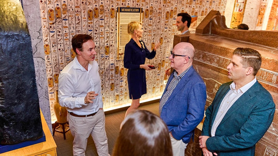 Visitors in a room with Egyptian hieroglyphs during the Tomb of the Pharaoh tour in Cairns, Australia.