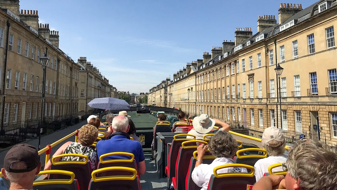 Open-top bus tour through Georgian architecture in Bath, England.
