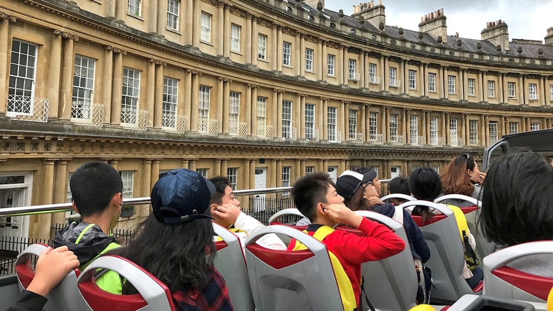 Open-top bus tour passing the Royal Crescent in Bath, England.
