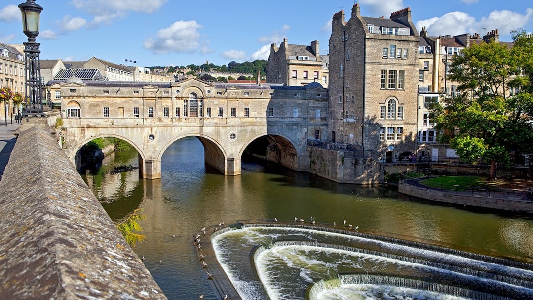 Pulteney Bridge over River Avon in Bath, featuring historic architecture and cascading weir.