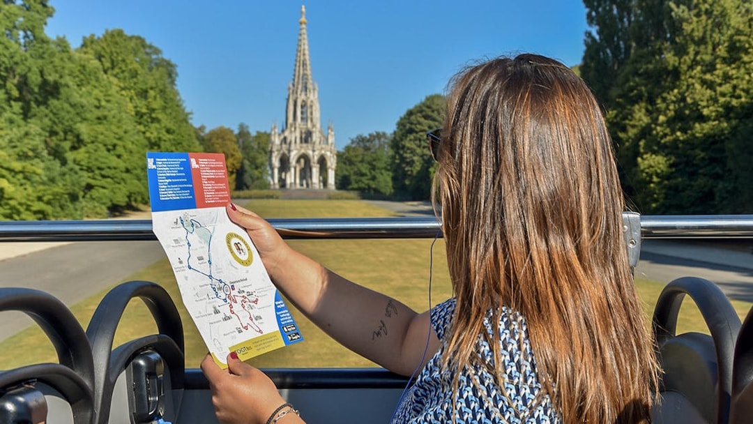 Tourist on Brussels bus tour holding map with view of the Church of Laeken.