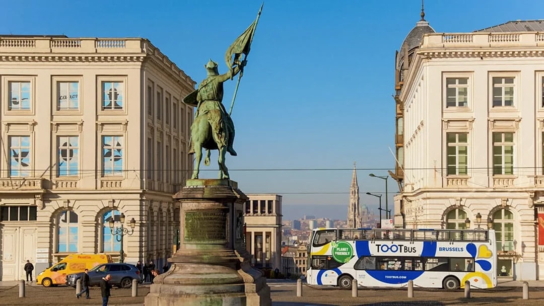 Statue of Godfrey of Bouillon with hop-on hop-off bus in Brussels city center.