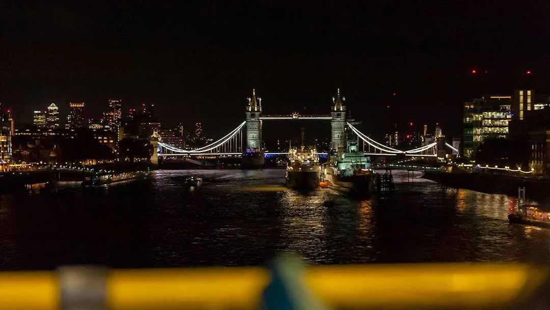 Tower Bridge illuminated at night over the River Thames in London.