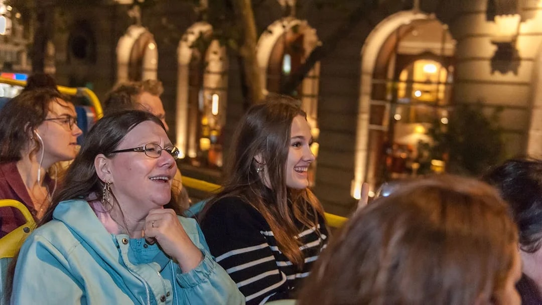 Passengers enjoying Tootbus London evening tour on an open-top bus.