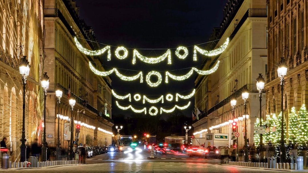 Paris street adorned with Christmas lights at night.