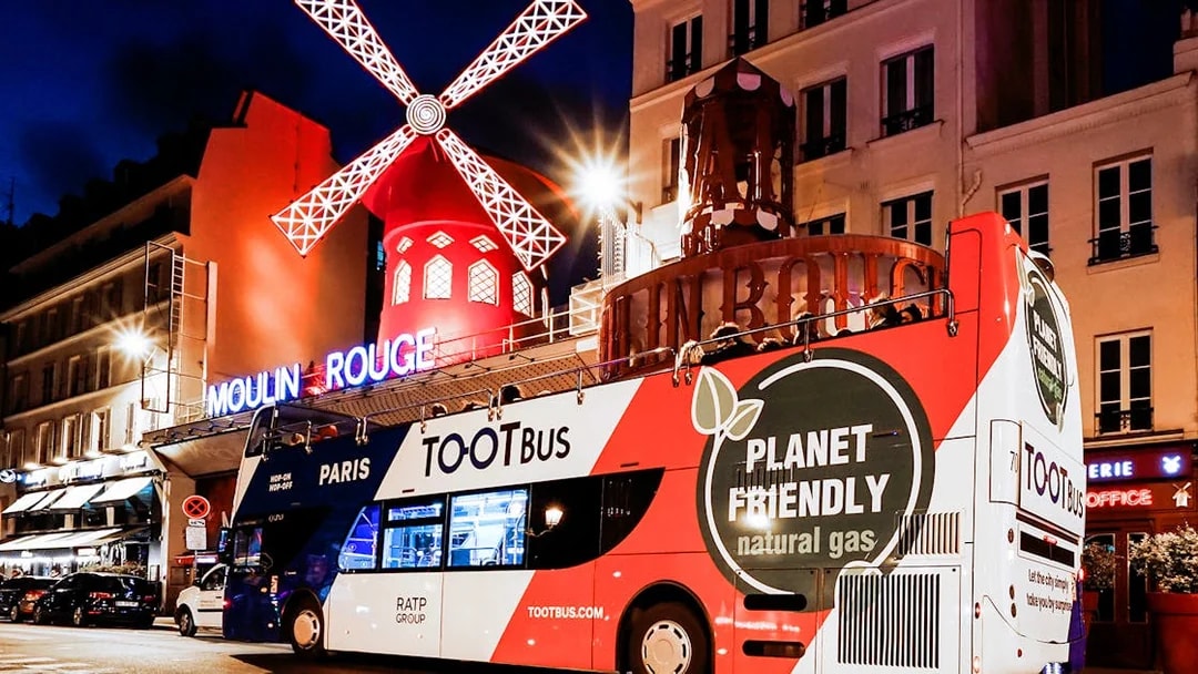 Tootbus in front of Moulin Rouge during a Paris night tour.