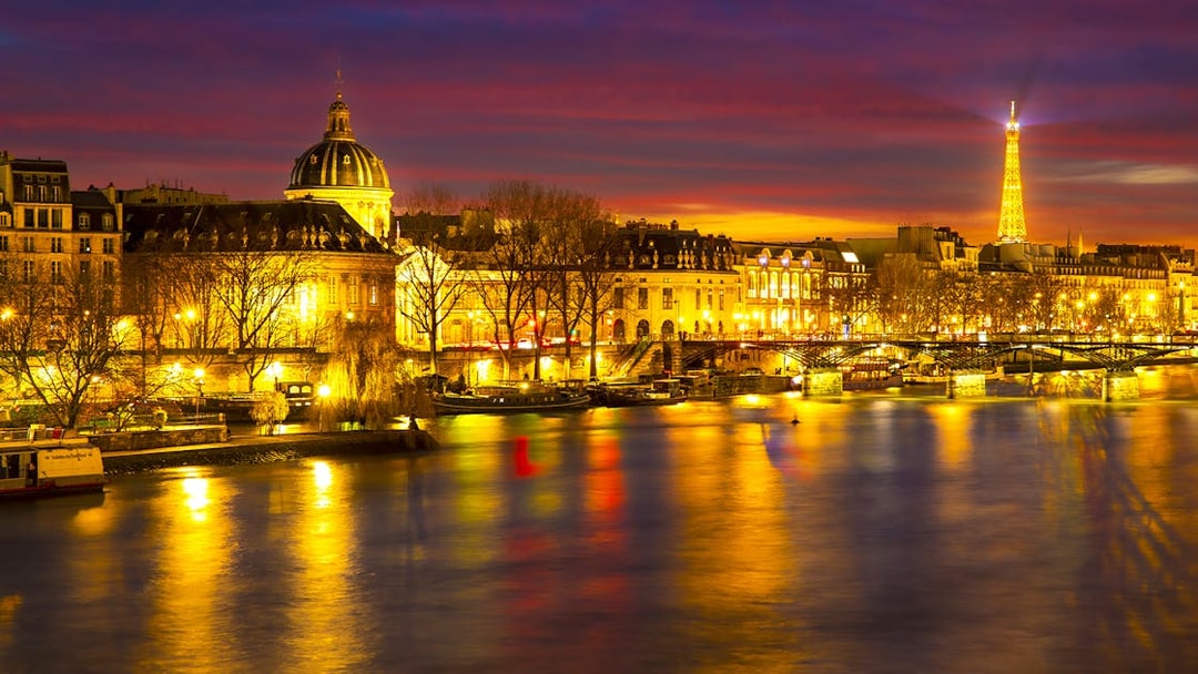 Paris night view with Eiffel Tower and Seine River, part of Tootbus Discovery Tour.