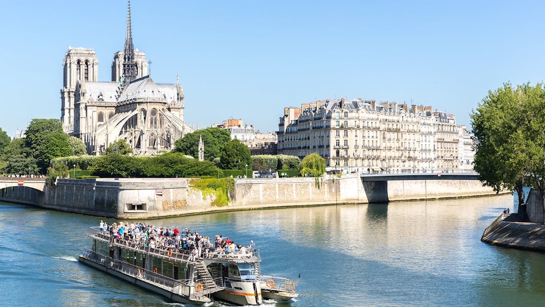 Cruise boat on the Seine River near Notre Dame Cathedral in Paris.