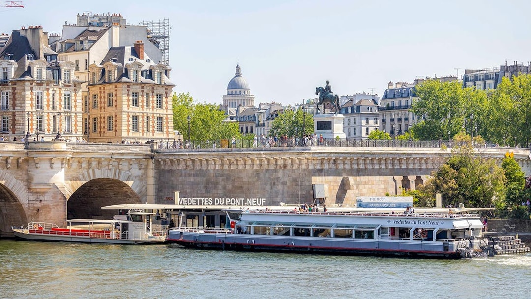 Seine river cruise boat docked at Pont Neuf in Paris.