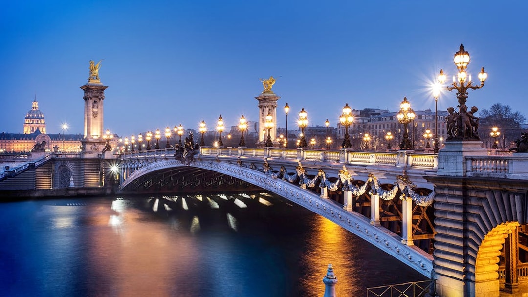 Pont Alexandre III illuminated at night, Paris, viewed from the Seine River.