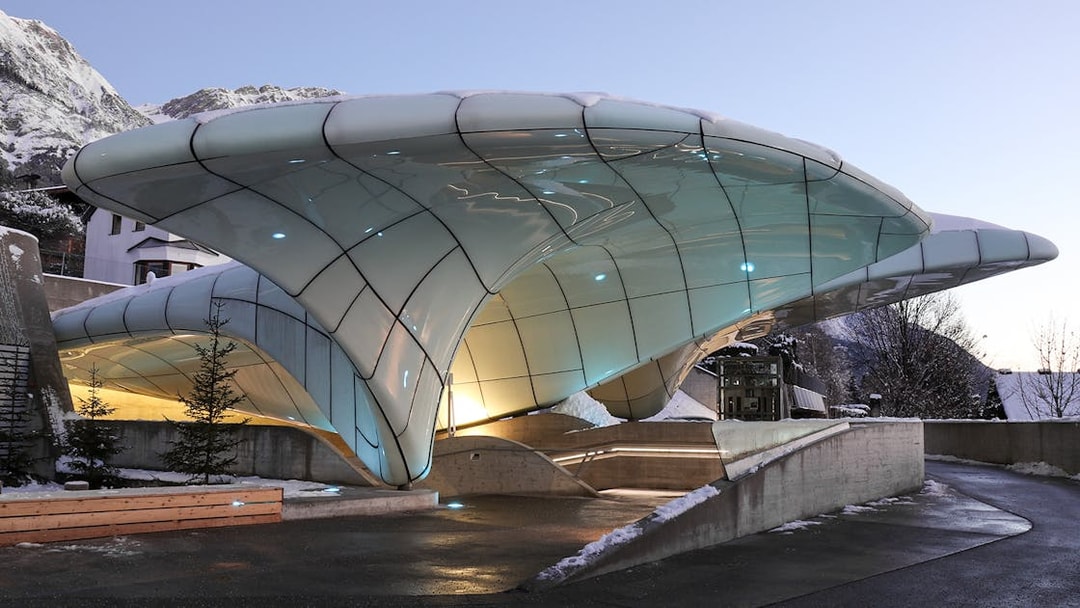 Nordkettenbahn station with modern architecture in Innsbruck, Austria, against a mountain backdrop.