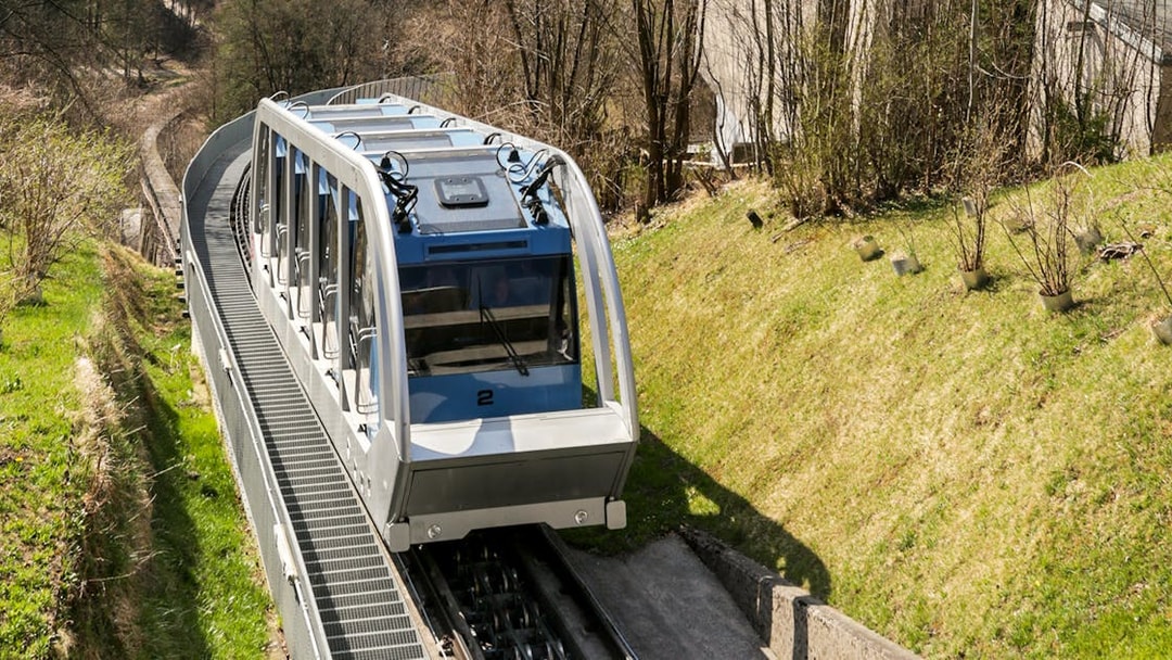 Nordkettenbahn funicular ascending through forested area in Innsbruck.