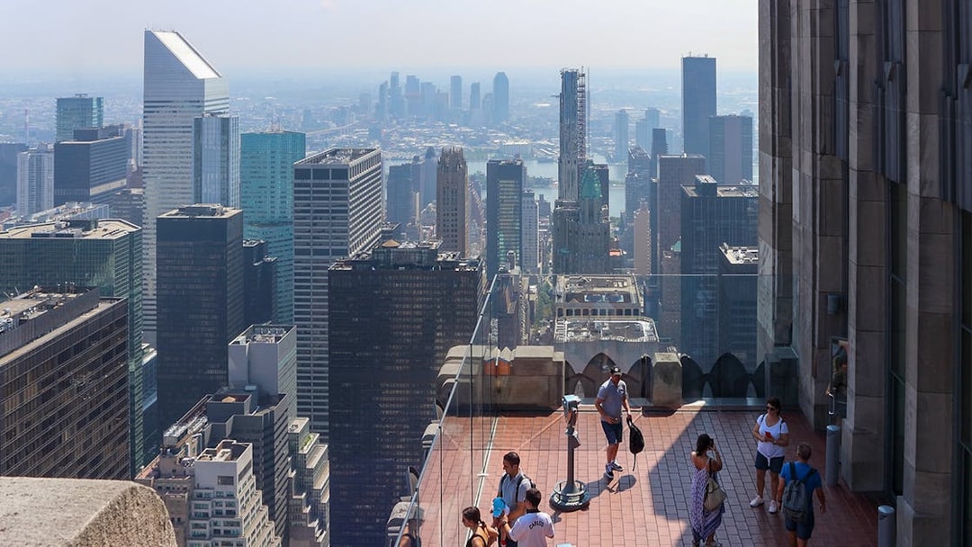 Visitors enjoying the view from Top of the Rock Observation Deck in New York City.