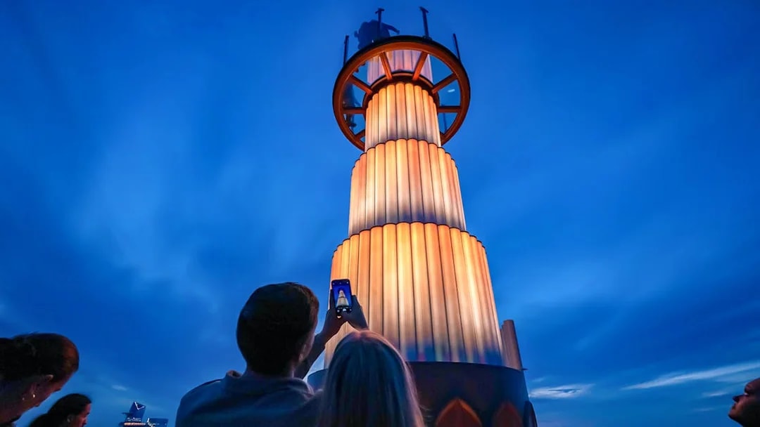 Visitors photographing the illuminated tower at Top of the Rock Observation Deck, New York City.
