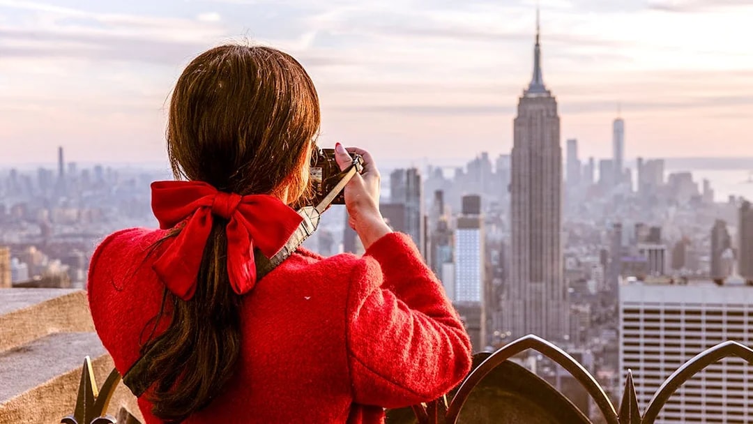 Visitor photographing Empire State Building from Top of the Rock, New York City.