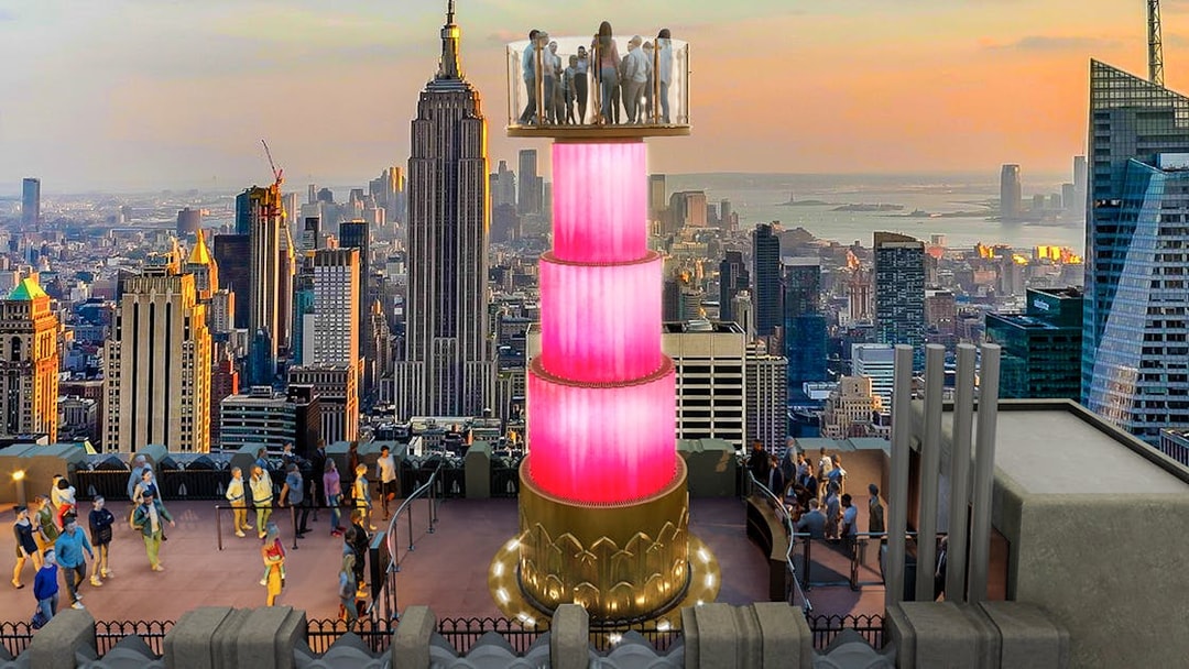 Visitors at Top of the Rock Observation Deck with Empire State Building view.
