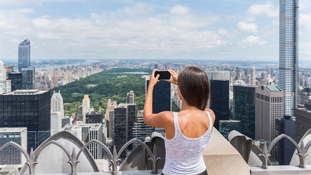 Visitors capturing New York City skyline from Top of the Rock Observation Deck.
