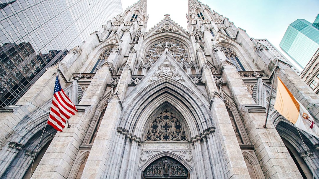 St. Patrick's Cathedral Gothic Revival facade, New York City, with American flag.