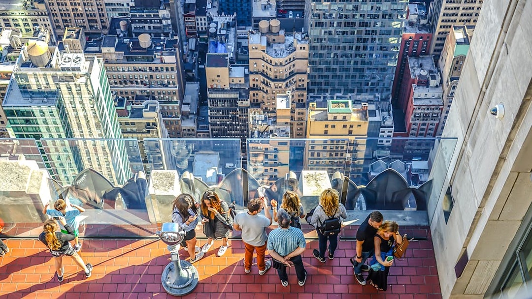 Visitors on the observation deck at Rockefeller Center overlooking New York City buildings.