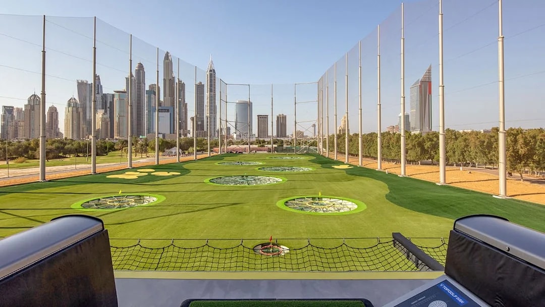 Topgolf Dubai driving range with city skyline in the background.