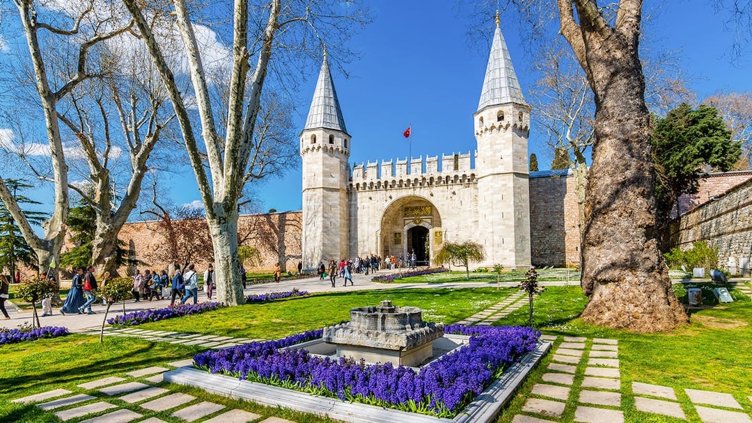 Gate of Salutation at Topkapi Palace, Istanbul, with gardens and visitors.