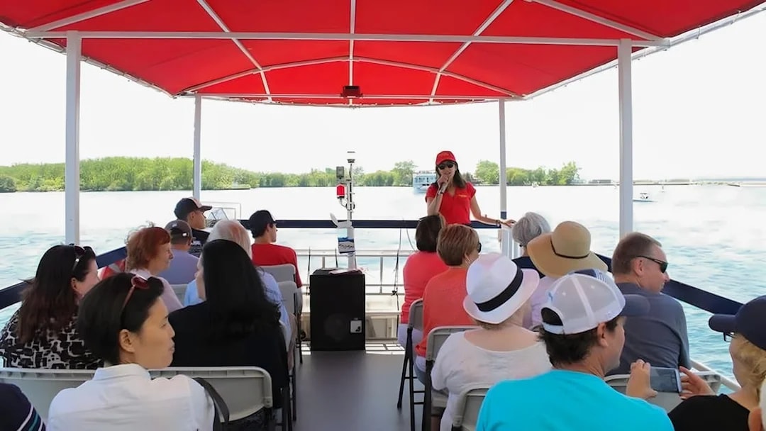 Tour guide speaking to passengers on a Toronto Harbour cruise boat.