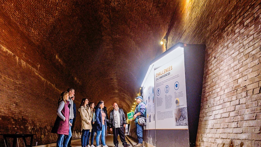 Visitors in a tunnel at Niagara Falls, viewing an informational display.