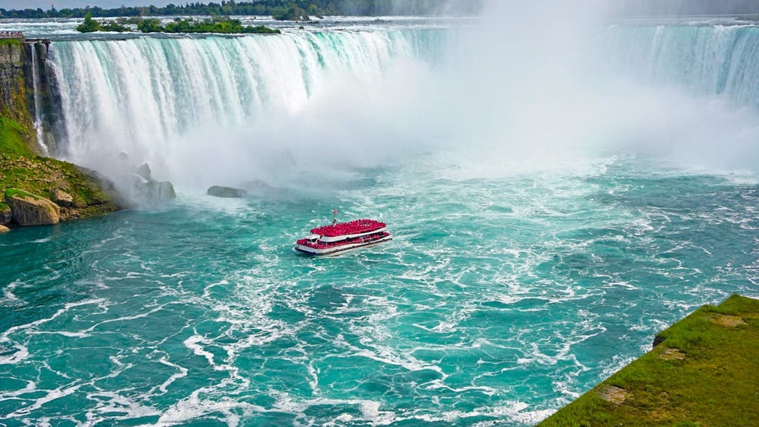 Aerial view of Niagara Falls with tour boat in the water.
