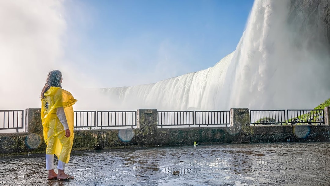 Person in yellow poncho viewing Niagara Falls from observation deck.