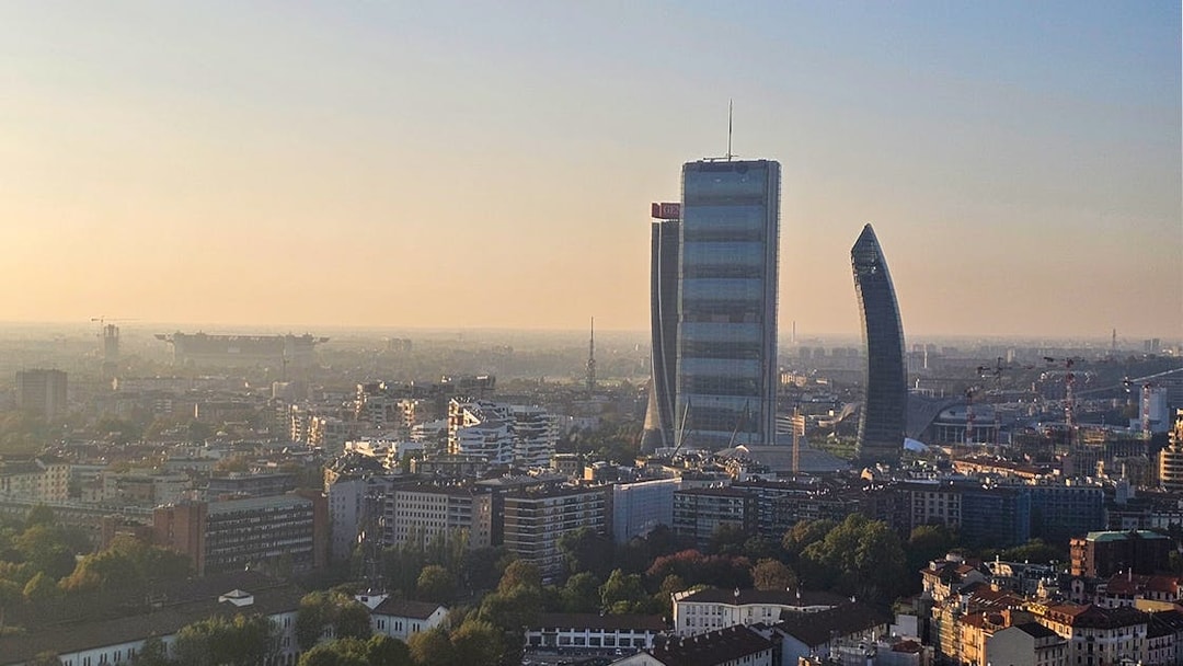 Milan skyline view with Torre Branca and modern skyscrapers at sunset.