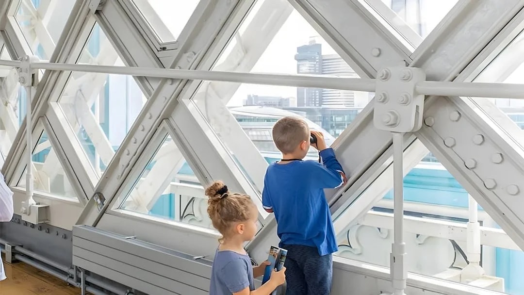 Children observing London skyline from inside Tower Bridge.