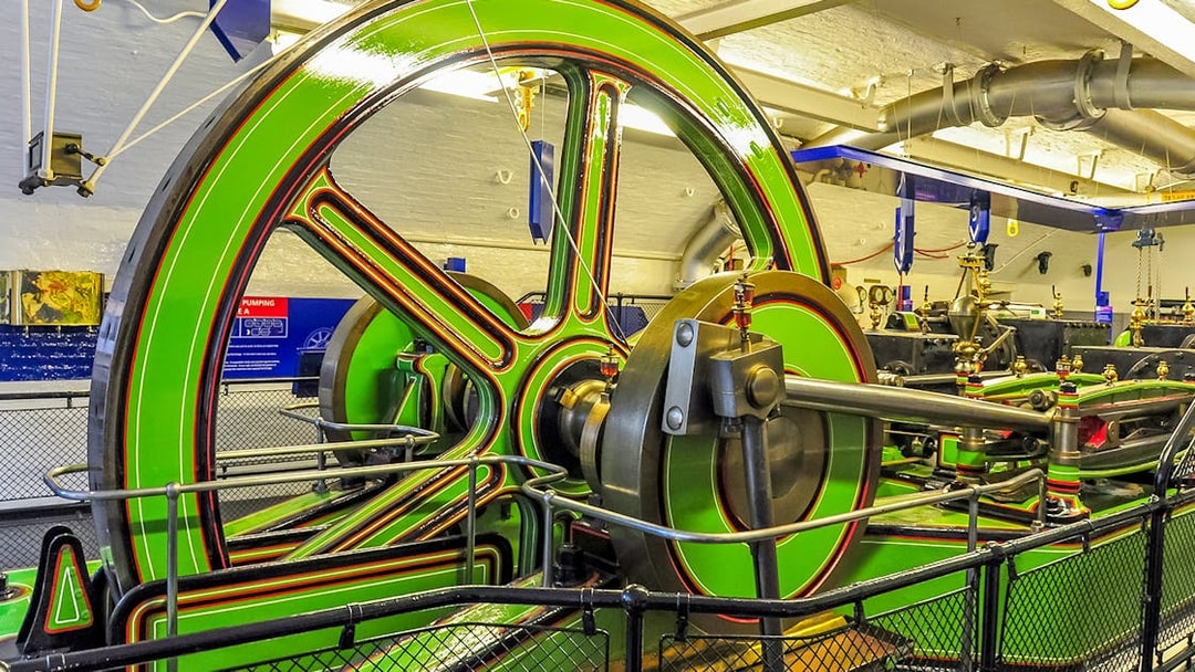 Tower Bridge Engine Room machinery with large green flywheel and pistons.