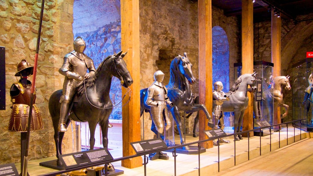 Medieval armor display with knights on horseback at a historical museum.