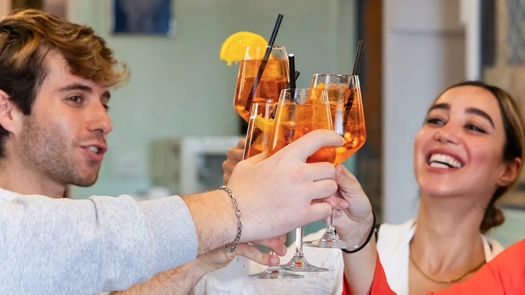 People toasting with Aperol Spritz at a Rome cooking class.